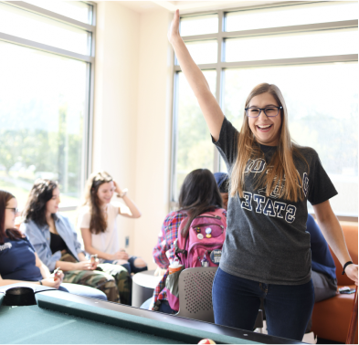 student cheering by a pool table